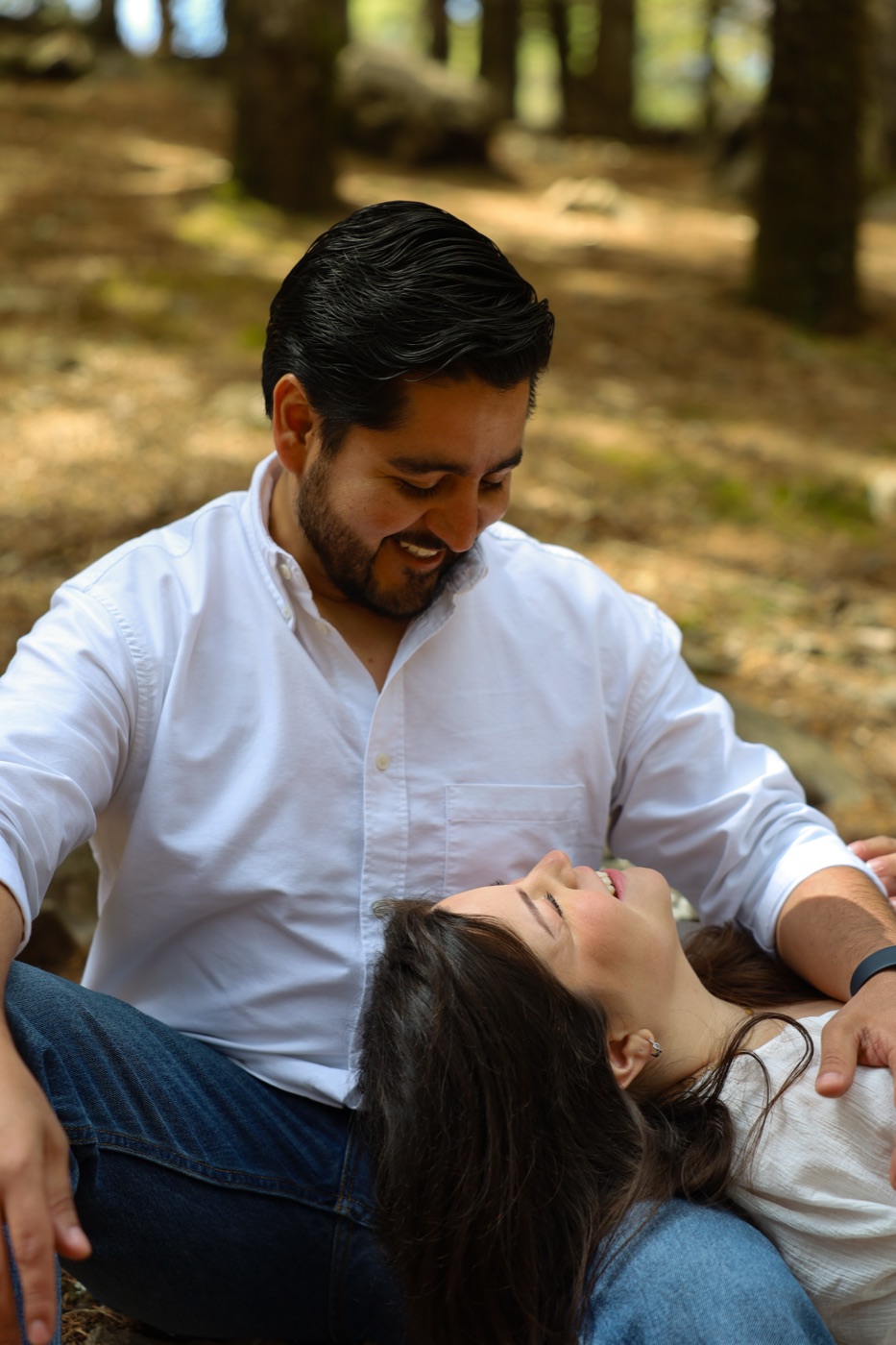 Pareja recostada sobre el pasto durante una sesión de save the date